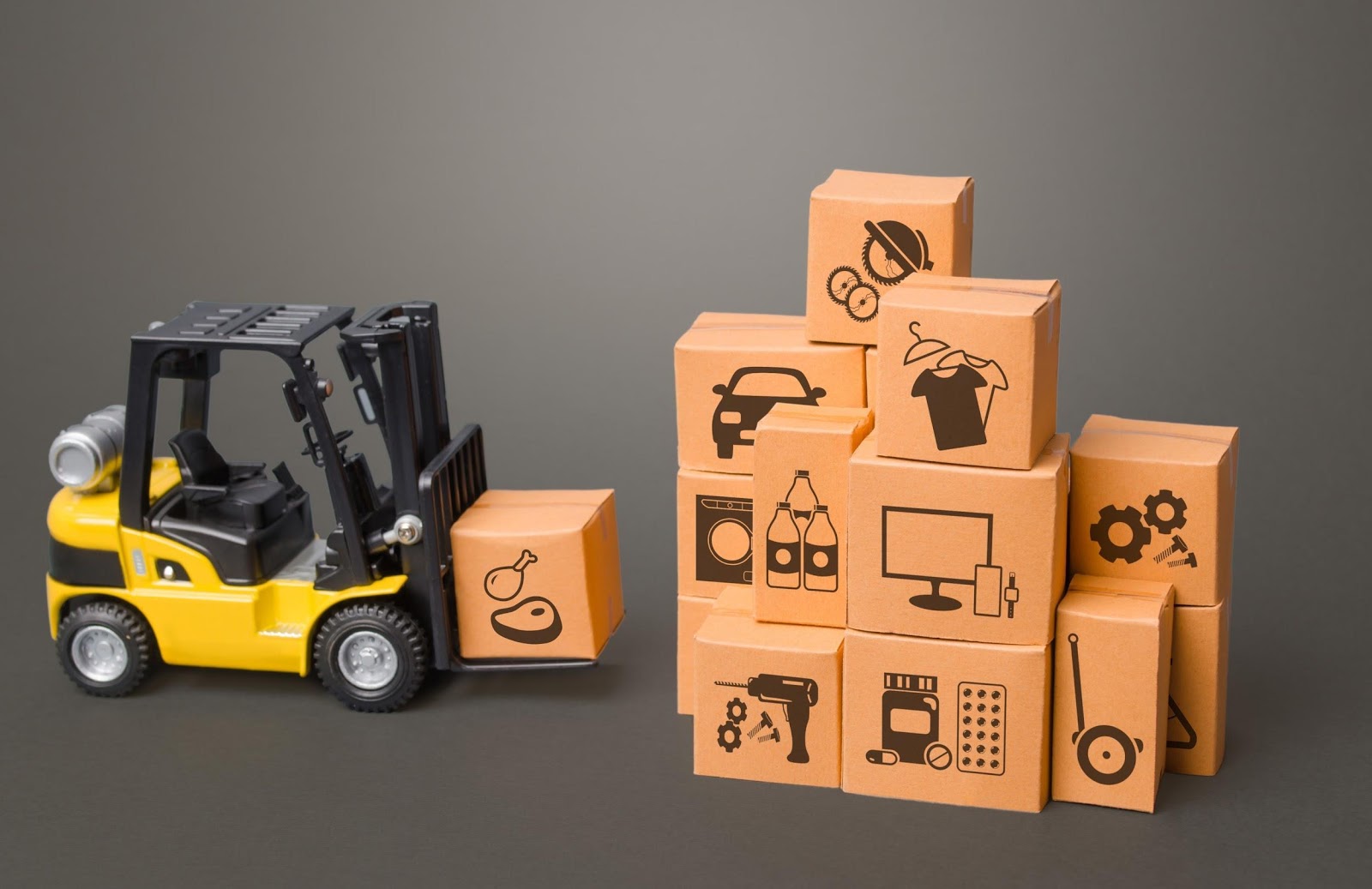 A toy forklift approaches toy boxes that each have symbols on them. Symbols include clothing, electronics, and tools. 