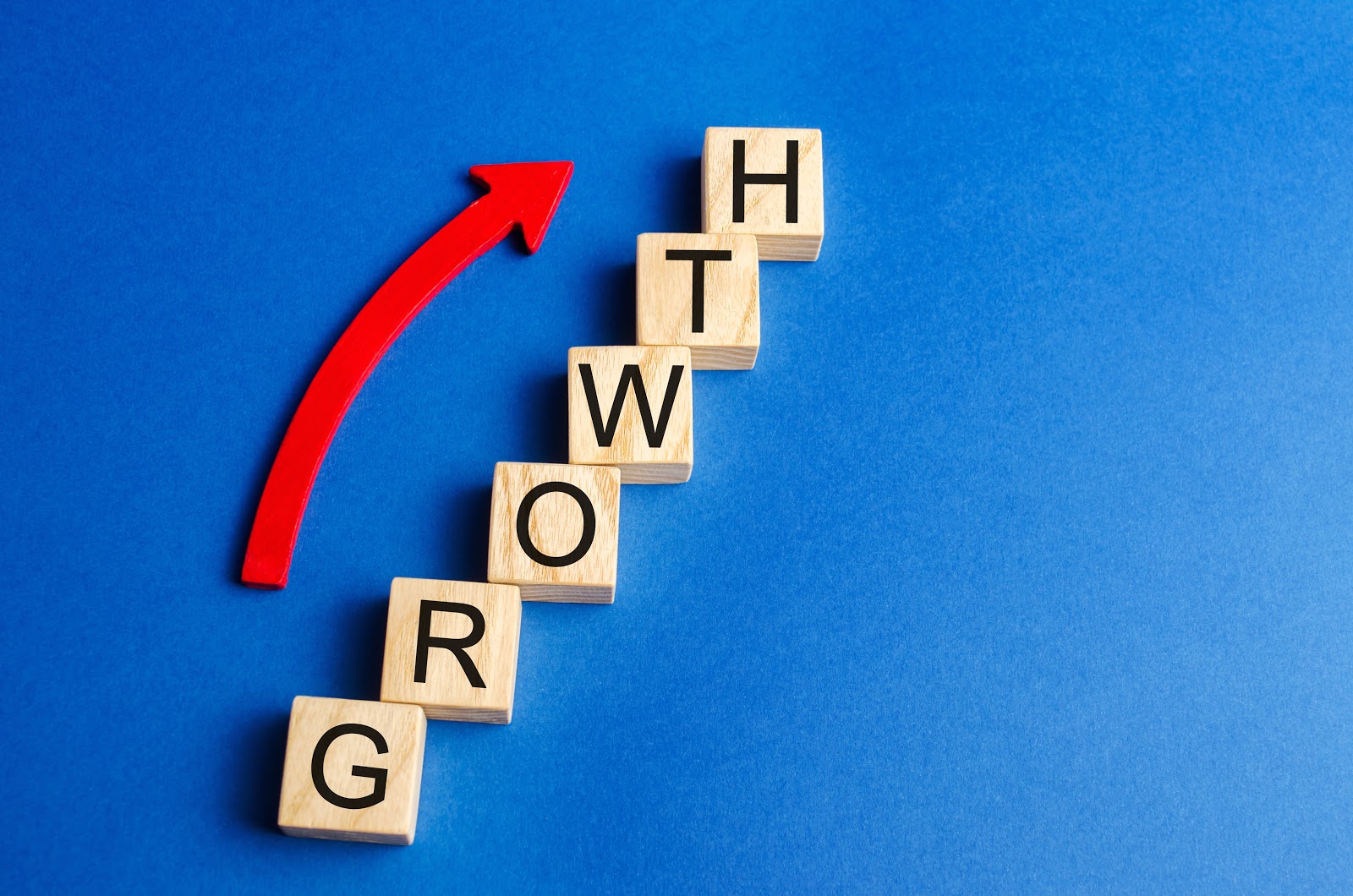 Letter tiles spelling out "growth" appear on a blue background. A red arrow points up. 