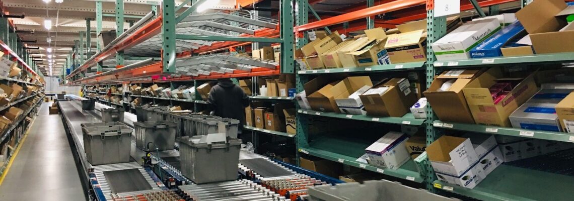 warehouse shelves are pictured as a box moves down a conveyor belt