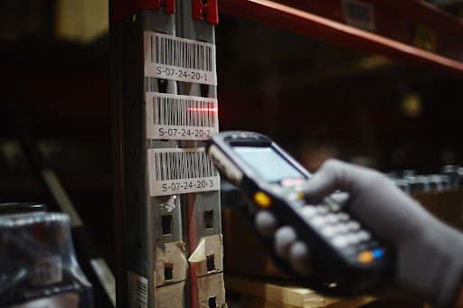 Warehouse worker scanning serial or batch number on packaging.